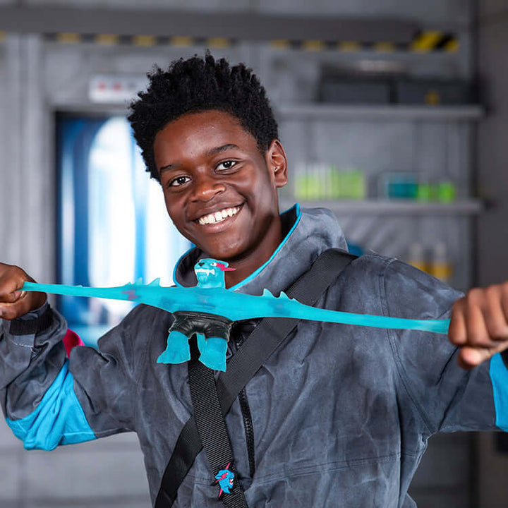 Child stretching MrBeast Lab Goo Jit Zu Hypercharged Panther toy in science lab setting.